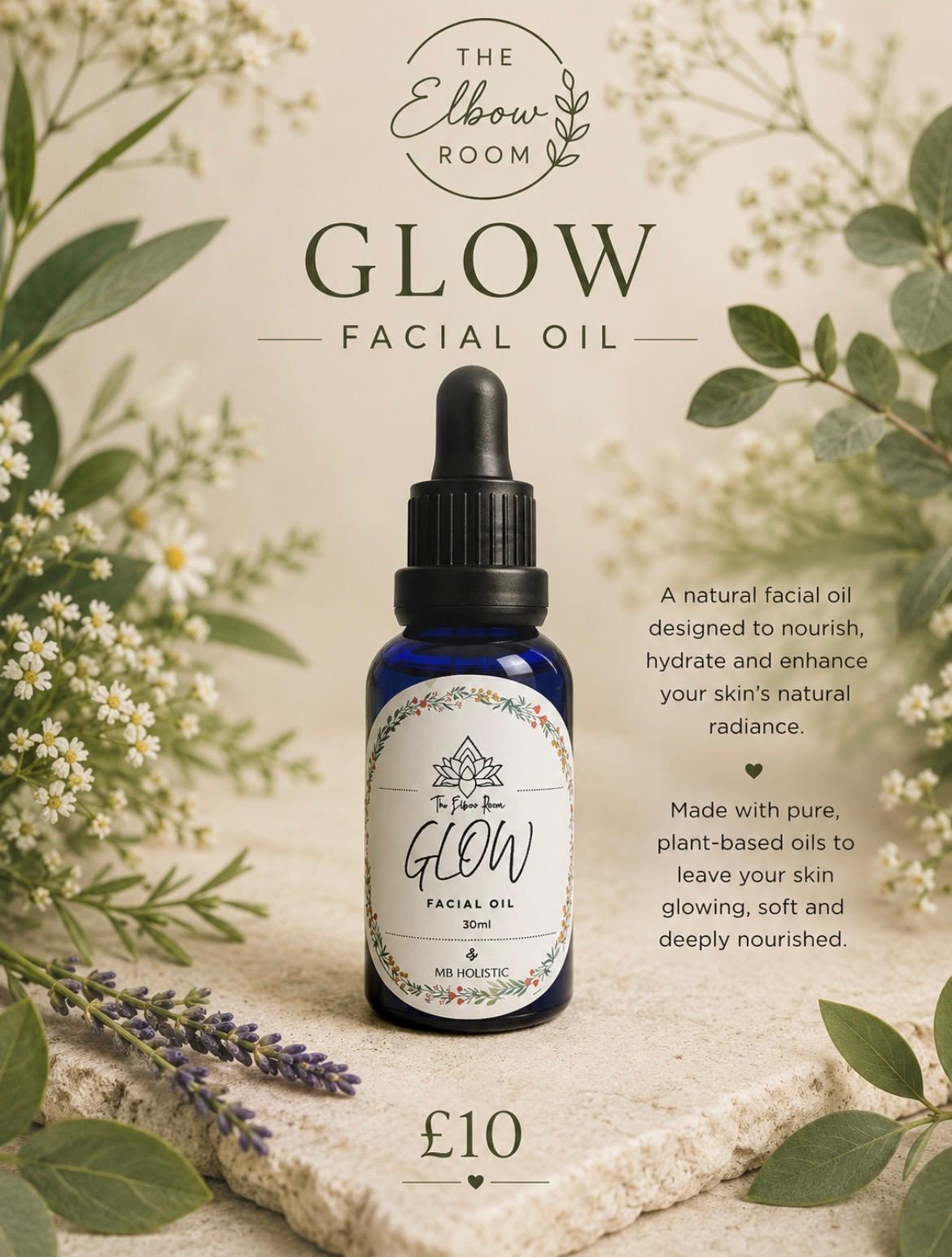Glow Facial Oil in a dark blue dropper bottle, surrounded by chamomile flowers and greenery