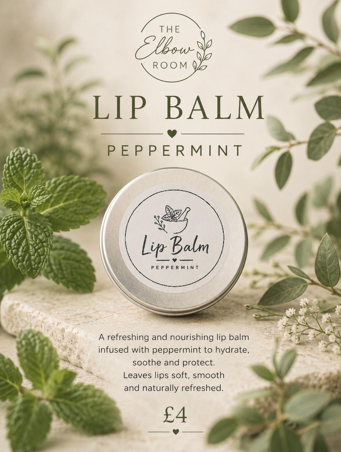 Peppermint Lip Balm tin resting on stone with fresh mint leaves